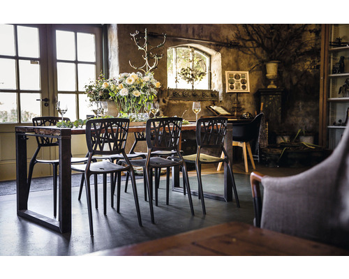 Eettafel met stoelen in een lichte ruimte met rustieke inrichting en bloemen