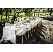 Gedekte tafel met stoelen in een lichte, ruime omgeving.