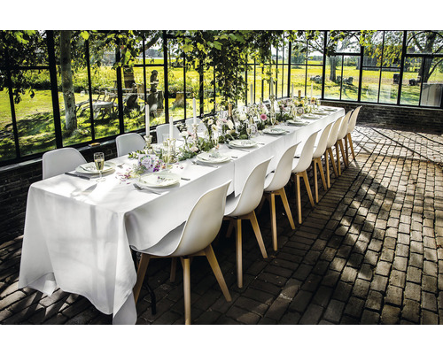 Gedekte tafel met stoelen in een lichte, ruime omgeving.