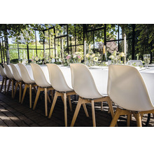 Feestelijk gedekte tafel met stoelen voor een evenement in de buitenlucht.