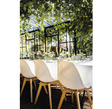 Feestelijk gedekte tafel in een serre met stoelen