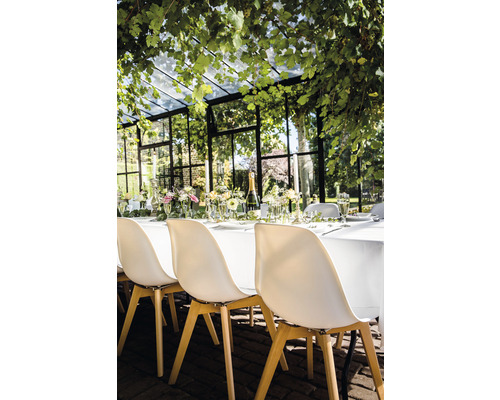 Feestelijk gedekte tafel in een serre met stoelen
