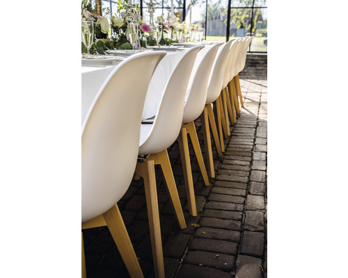 Rij eetkamerstoelen met houten poten aan een gedekte tafel