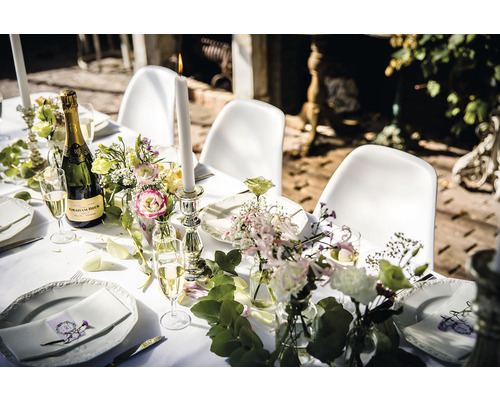 Feestelijk gedekte tafel met champagne, kaarsen en bloemen voor een feest