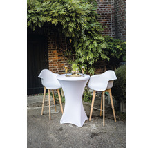 Sta-tafel met stretchhoes en barkrukken voor een bakstenen muur met begroeiing