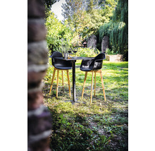 Tuinscene met kleine tafel, twee barkrukken, wijnglazen en decoratie