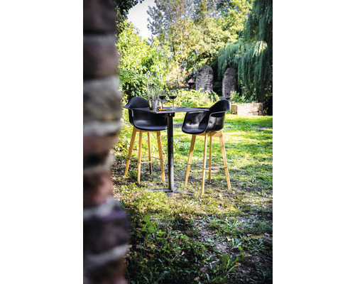 Tuinscene met kleine tafel, twee barkrukken, wijnglazen en decoratie