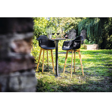 Tuinscene met een statafel en twee barkrukken op een gazon.