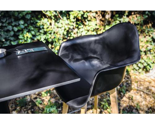 Zwarte tuinstoel en tafel met bestek buitenshuis.