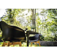 Tuinscène met tafel, twee stoelen, twee glazen wijn en een plant