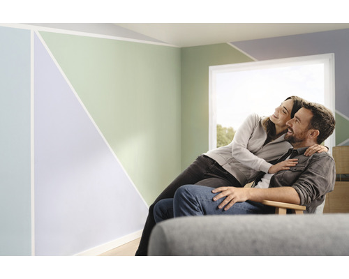 Een stel zit in een kamer met geometrische patronen op de muren.