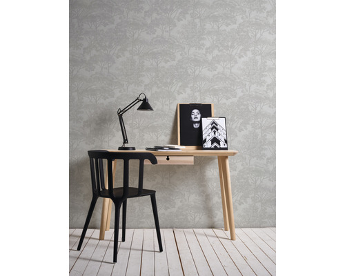 Inrichting met bureau, stoel, lamp, fotolijsten en behang met bosmotief.