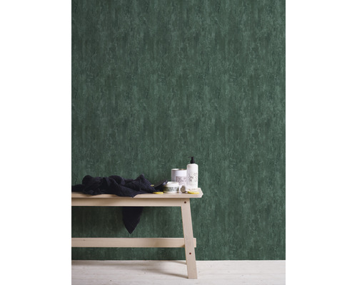 Kamerweergave met groen vliesbehang, bijzettafel en badkamerbenodigdheden.