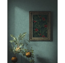Ingelijste foto met bloempatroon aan een muur met twee potplanten