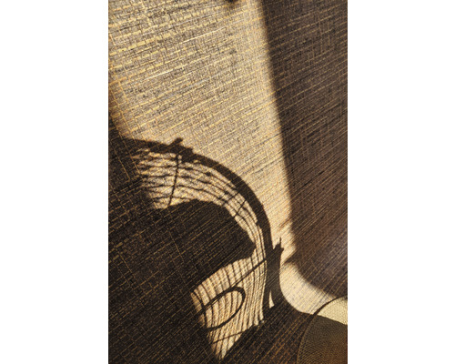 Close-up van een getextureerd gordijn met de schaduw van een rotan stoel