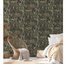 Slaapkamer met junglebehang met dieren- en plantenmotieven, bed en rotan stoel
