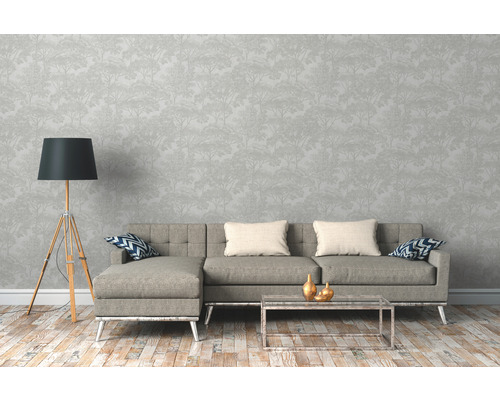 Woonkamer met grijze bank, staande lamp en behang met boommotief