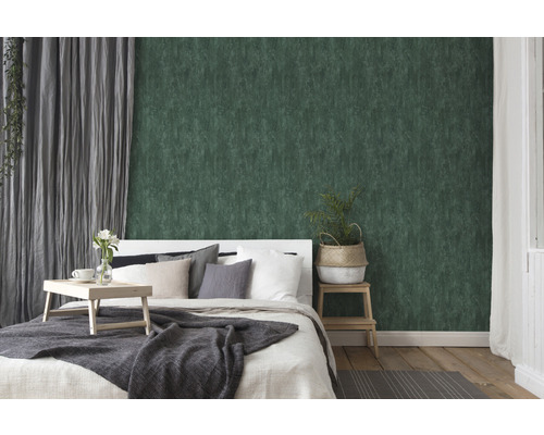 Slaapkamer met groen structuurbehang, bed en gordijnen.