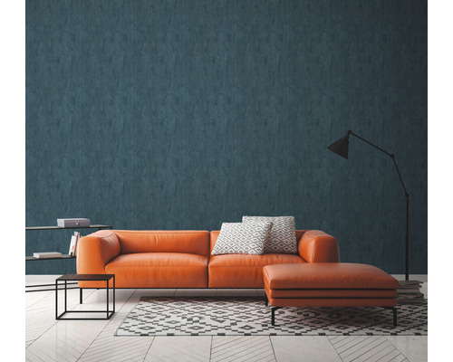 Woonkamer met oranje leren bank, patroontapijt en vloerlamp voor een wandbekleding