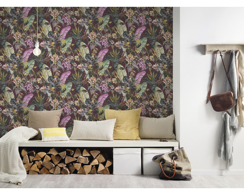 Woonkamer met junglebehang, bank, kussens, brandhout en accessoires voor een gezellige sfeer