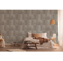 Slaapkamer met een wandbehang met dierenvelmotief en een tweepersoonsbed.