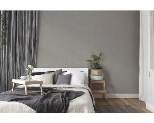 Slaapkamer met bed, gordijnen en grijs vliesbehang