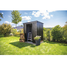 Metalen tuinhuis in de tuin met ladder, bloembak en houtblokken