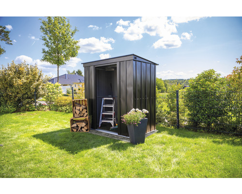 Metalen tuinhuis in de tuin met ladder, bloembak en houtblokken