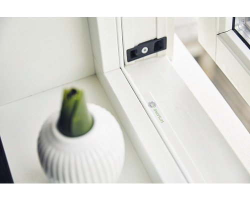 Detailopname van een wit kunststof kozijn met vensterbank en decoratie