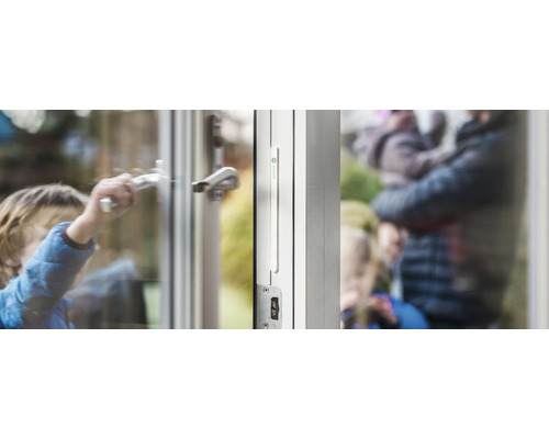 Kind opent raam met raambeveiliging