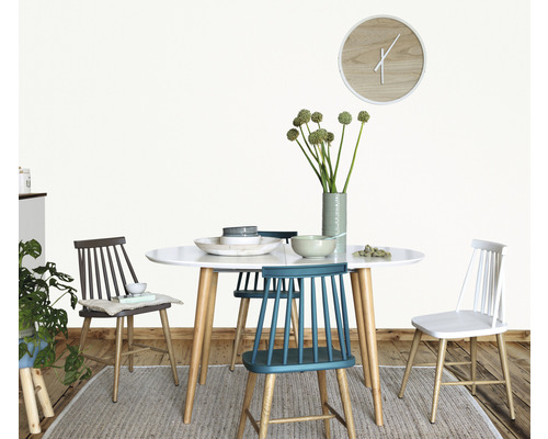 Eettafel met stoelen, servies en bloemenvaas in een lichte kamer