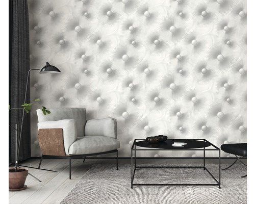 Woonkamer met fauteuil, tafel en behang met knoopmotief