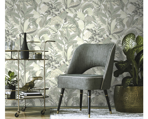 Scene met bloemenbehang, fauteuil en serveerwagen.