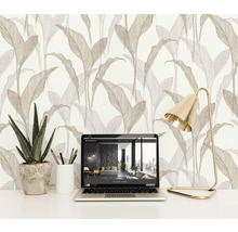 Scene met vliesbehang met bladerpatroon, laptop, bureaulamp en plant in pot