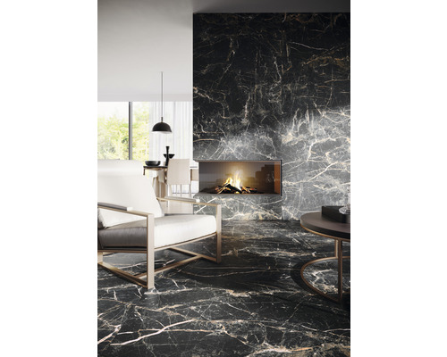 Woonkamer met donkere marmeren tegels, open haard en moderne fauteuil