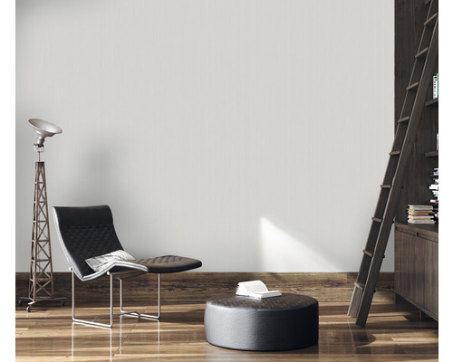 Woonkamer met fauteuil, staande lamp en boekenkast met ladder