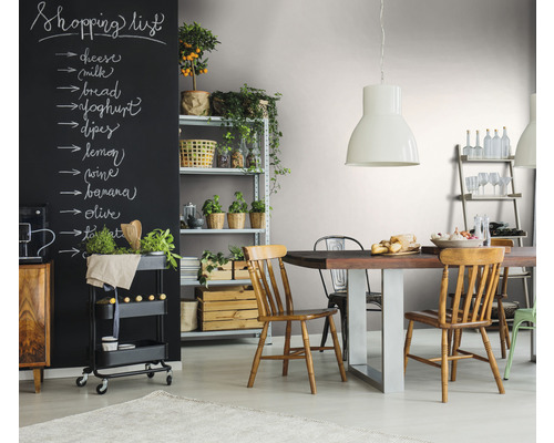 Eetkamer met eettafel, stoelen, rek en zwart schoolbord met boodschappenlijst