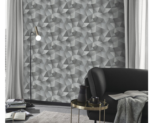 Woonkamer met geometrisch behang, staande lamp en bank.