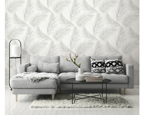 Woonkamer met grijze bank en behang met bladmotief
