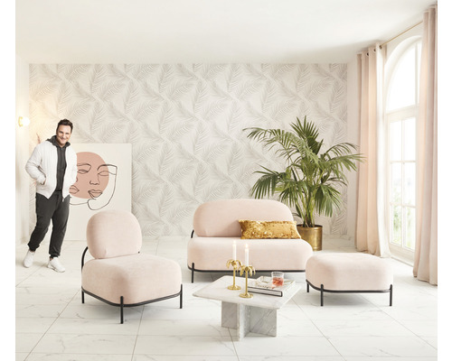 Lichte woonkamer met roze bank, fauteuil, voetenbank, marmeren tafel, palmboom en man