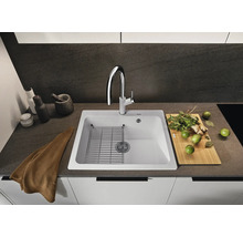 Spoelbak met afdruiprek, kraan, snijplank en keukengerei op een aanrecht