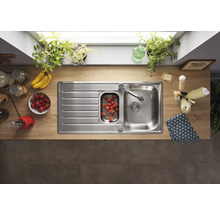 Roestvrijstalen spoelbak met afdruiprek en inbouwspoelbak in een lichte keuken.