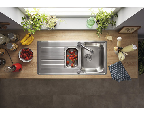 Roestvrijstalen spoelbak met afdruiprek en inbouwspoelbak in een lichte keuken.