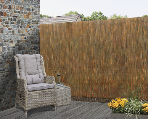 Terrasscène met rotanmeubels en rietmat als privacyscherm