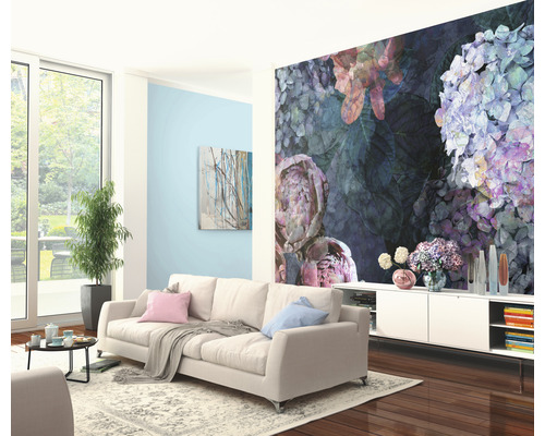 Woonkamer met bank, dressoir en bloemendecoratie aan de muur