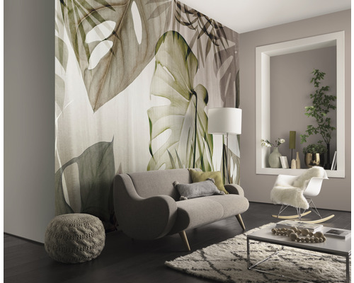 Woonkamer met groot fotobehang met plantmotieven, bank, vloerkleed en decoratie