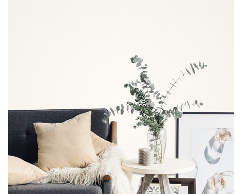 Woonkamer met grijze bank, kussens, bijzettafel, vaas met eucalyptus en fotolijsten.