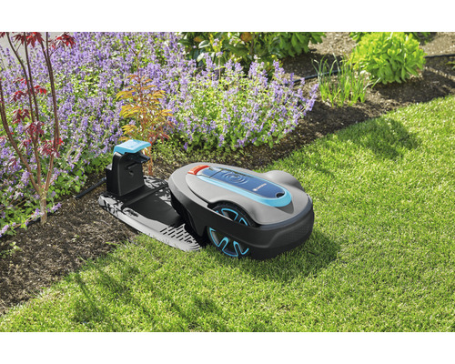 Gardena robotmaaier op een gazon naast bloemperken