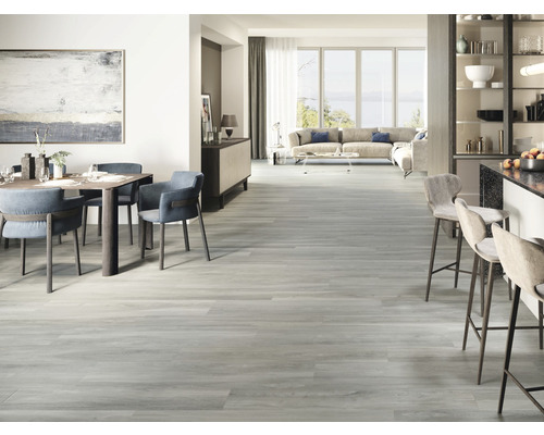 Lichte woonkamer met eettafel, stoelen, barkrukken, bank en houten vloer