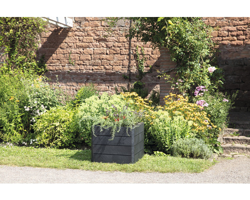 Vierkante kunststof plantenbak in een tuin met bloemen